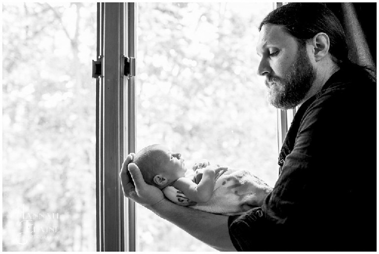 dad holding son in front of nursery window