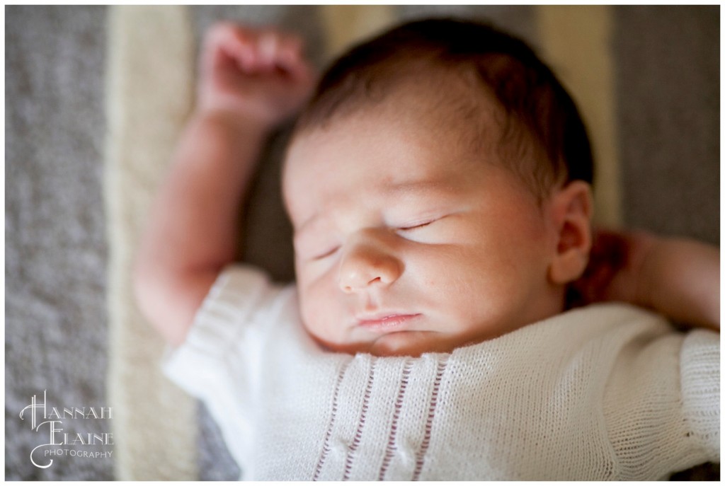 baby boy sleeps in white sweater onesie