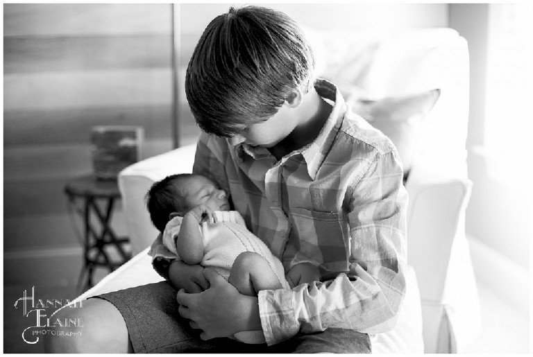 black and white pic of teenage boy holds his baby brother