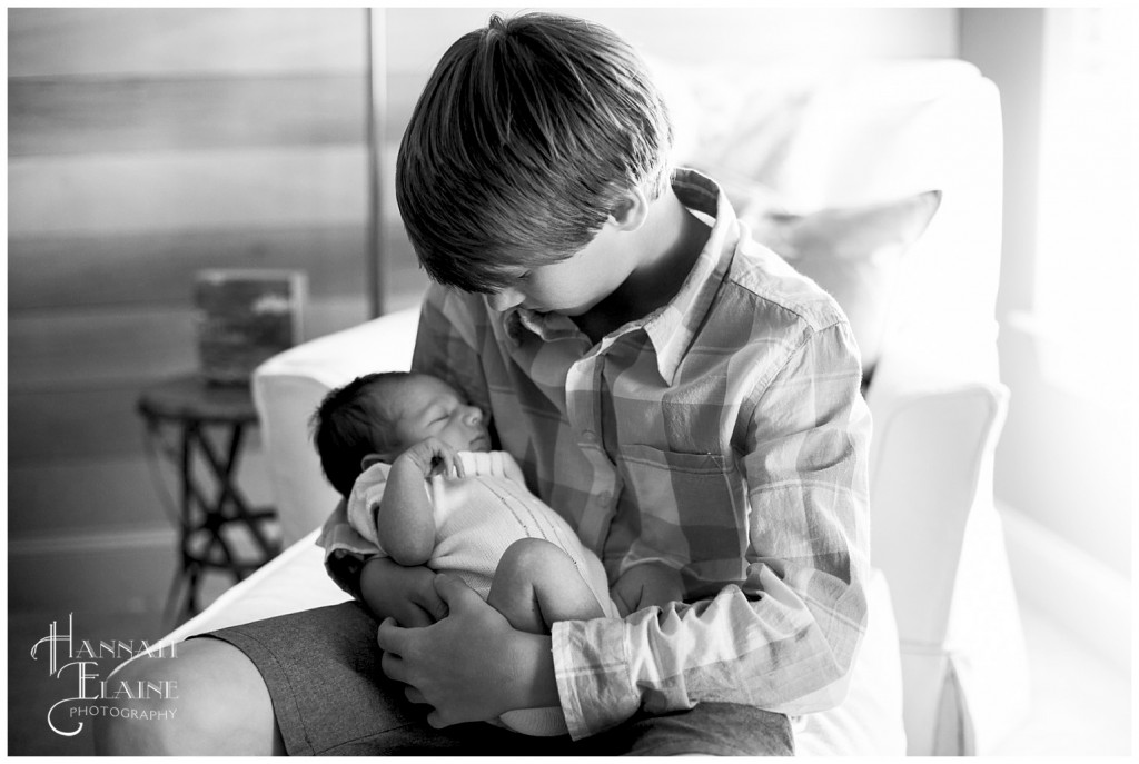 black and white pic of teenage boy holds his baby brother