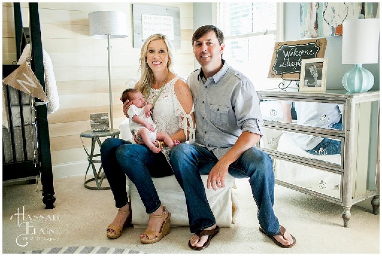 mom and dad proudly show off their son and his nursery