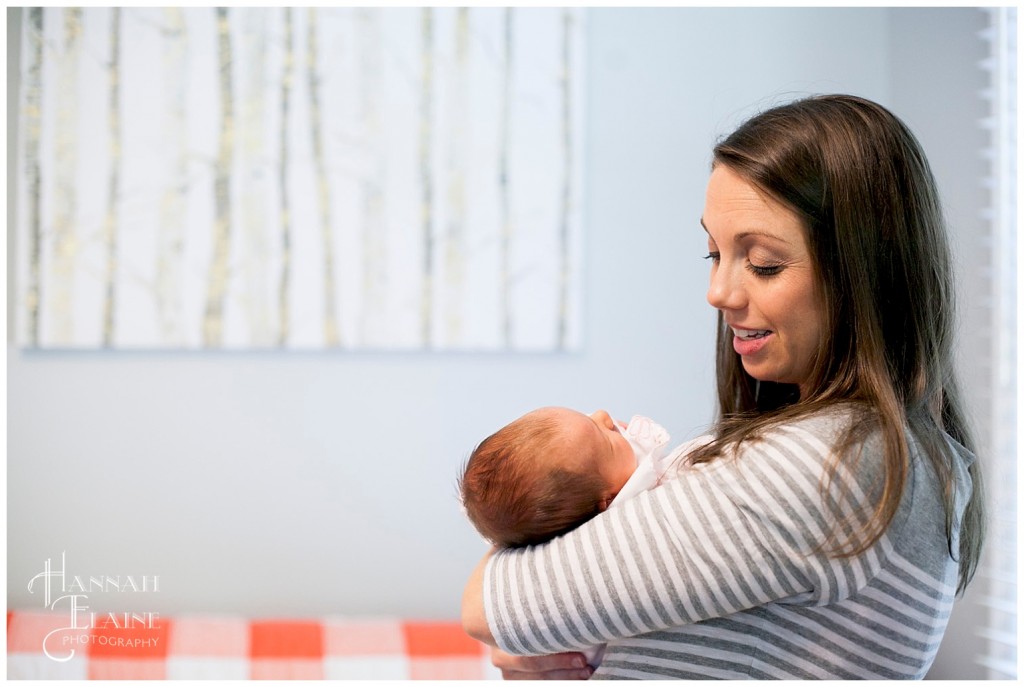 mom rocks her baby in the nursery