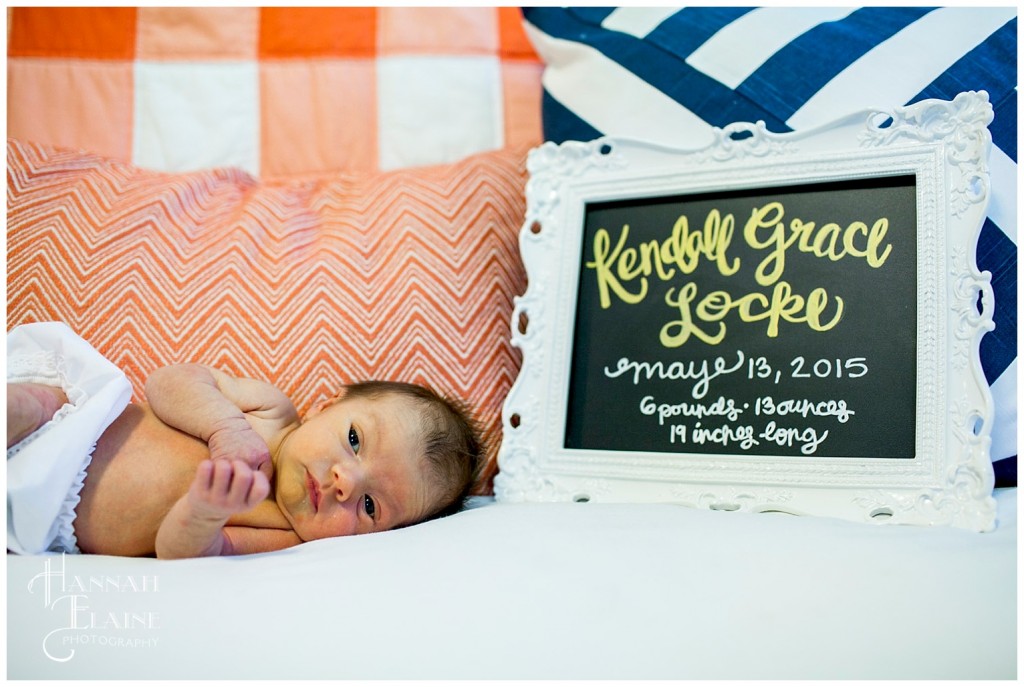 newborn lays next to custom chalkboard design