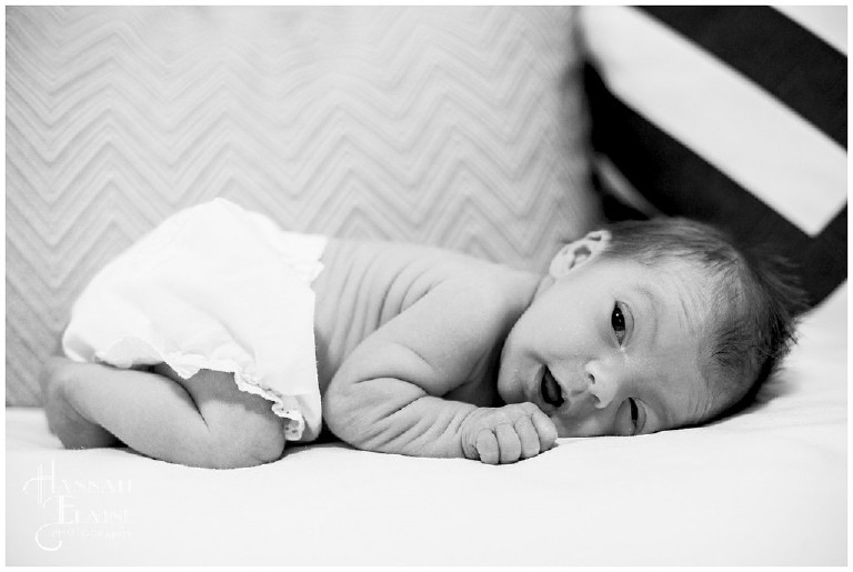 black and white image of newborn on tummy
