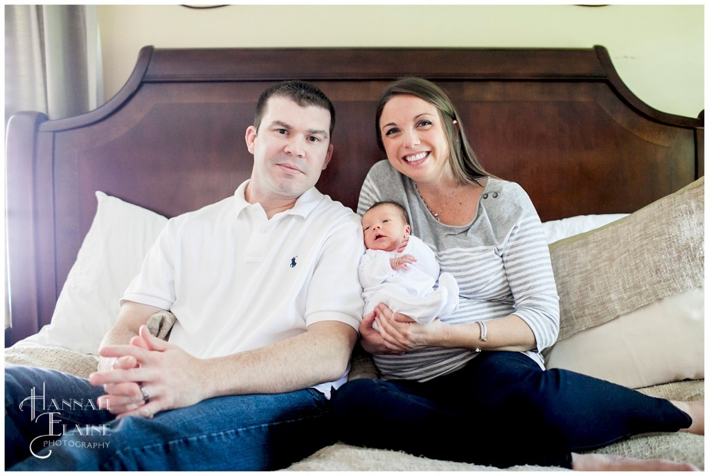 family of three pose for a portrait on the bed