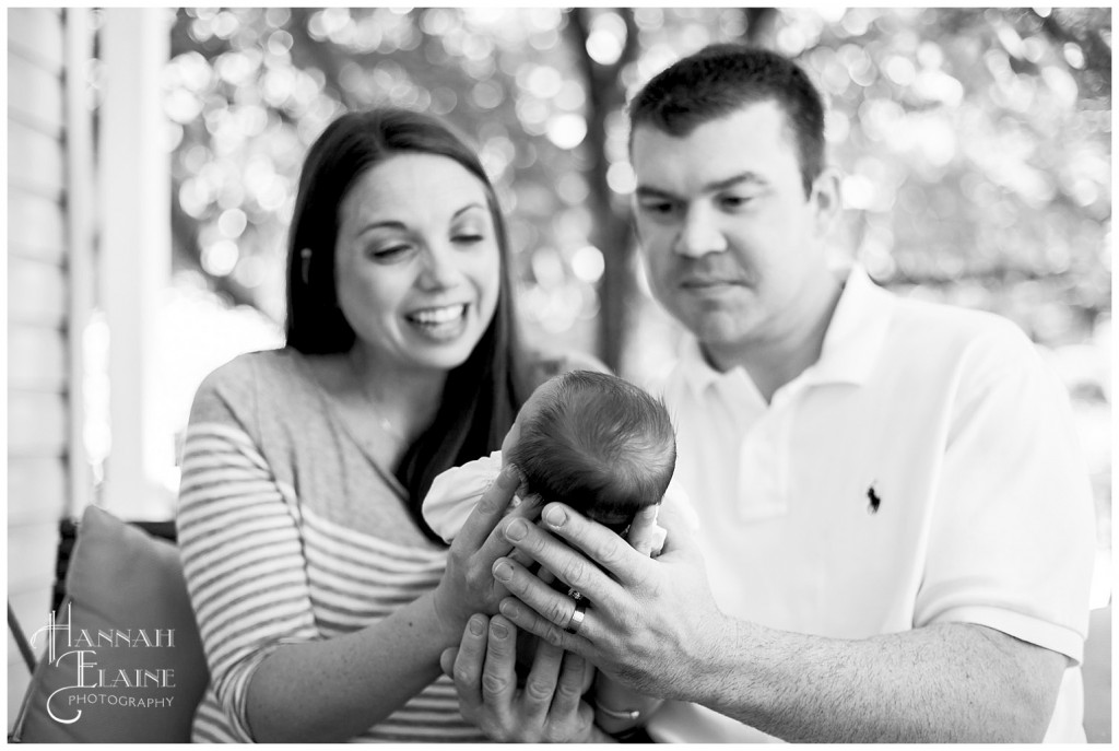 close up of parents hands holding newborn daughter's head