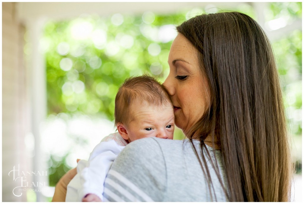 momma kisses her baby daughter's head