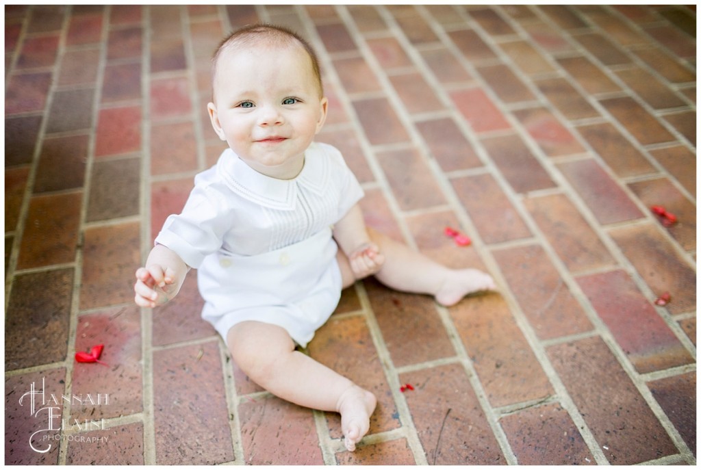 little boy grins on red brick path