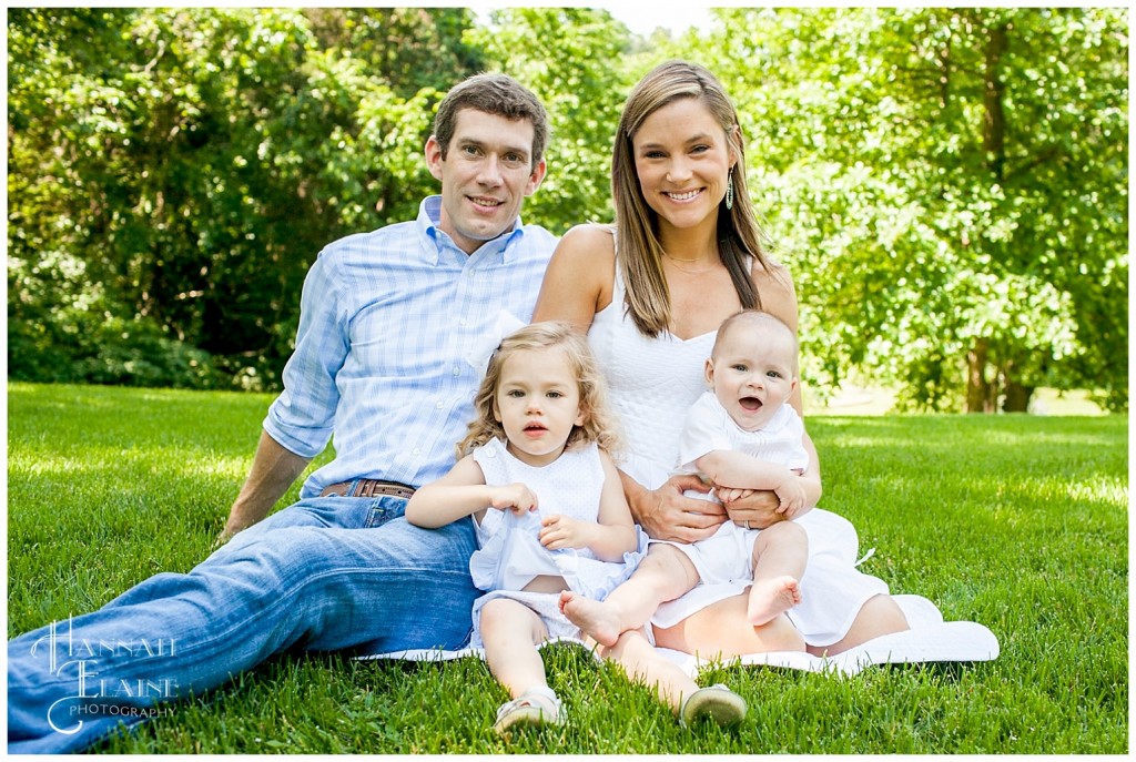 family on white blanket in the grass