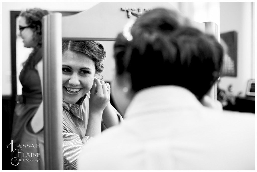 bride puts on her wedding day earrings