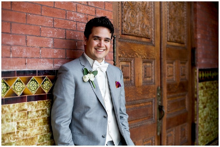 groom stands in the ornate vintage church lobby