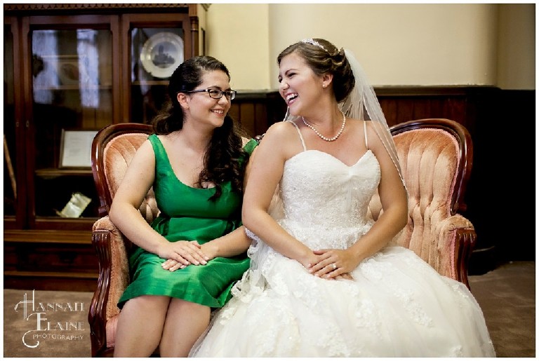 bride and her maid of honor smile at each other