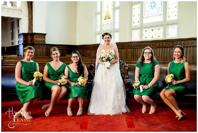 bride with bridesmaids in emeral green dresses in the church