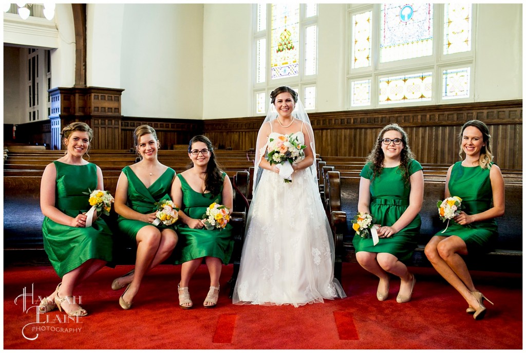 bride with bridesmaids in emeral green dresses in the church