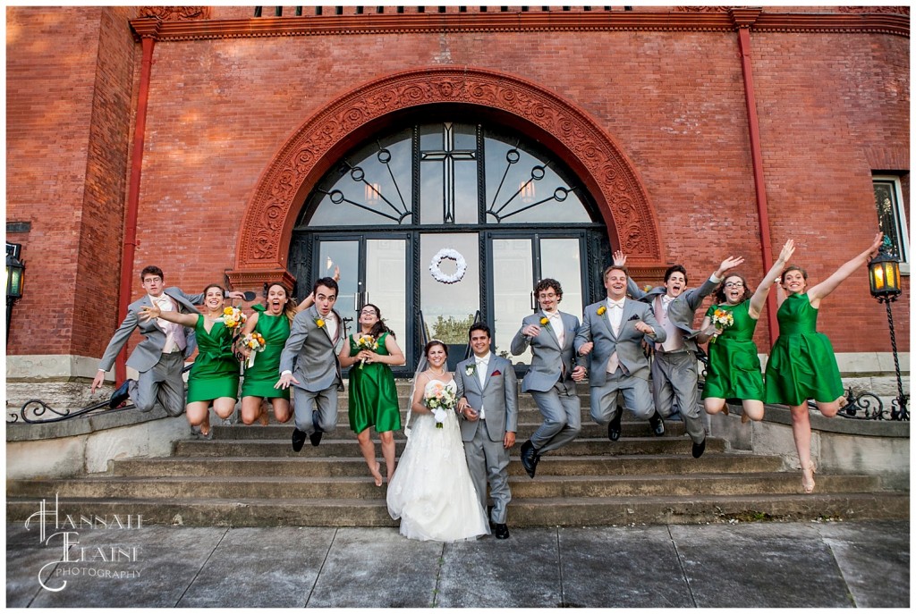 bridal party jumps off the front steps of the church