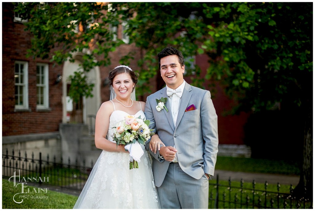 newly married couple stands together in the churchyard