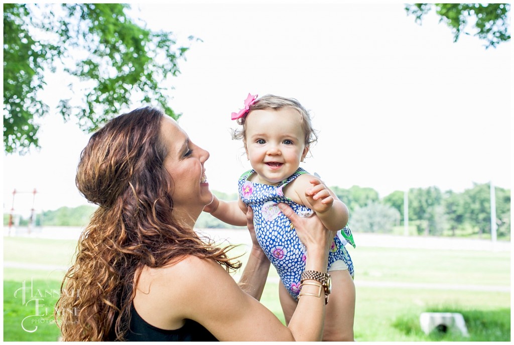 taylor smiles as mom throws her up in the air