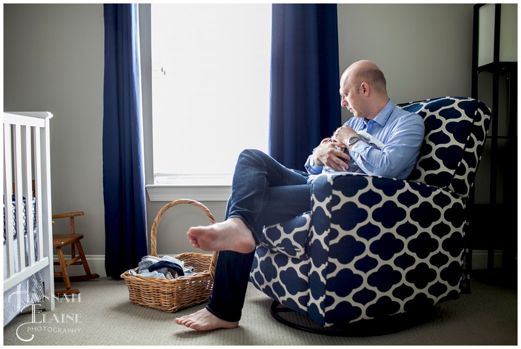 daddy in blue recliner rocks his baby to sleep