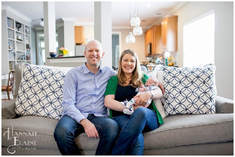 family with new baby on the living room couch