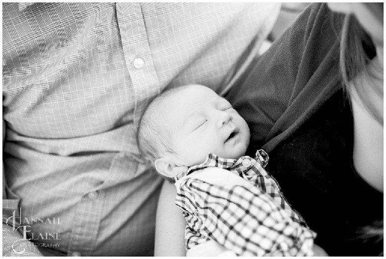 black and white image of newborn in plaid shirt