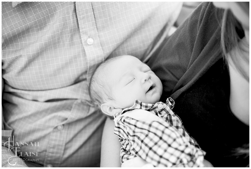 black and white image of newborn in plaid shirt