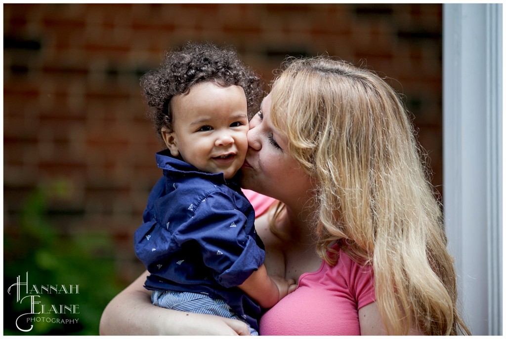 blond momma kisses her curly haired little boy