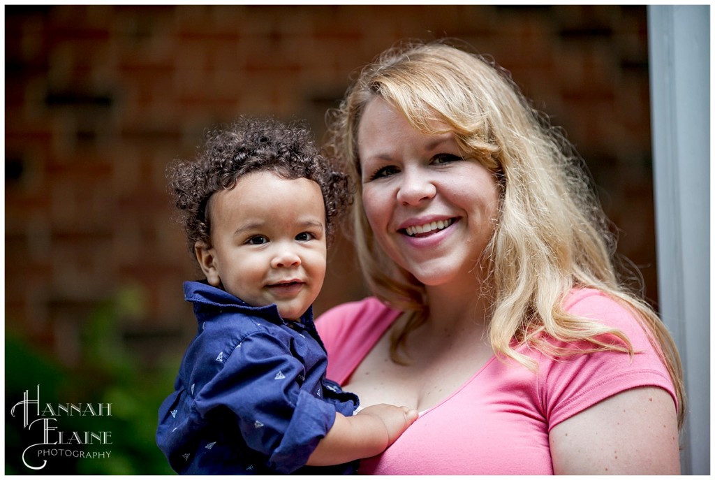 blond mom in pink shirt holds her little boy in blue shirt