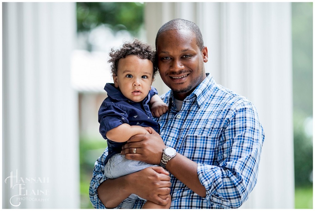 dad holds his son and smiles for a photograph