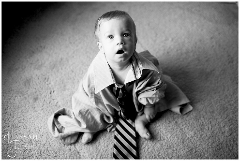 black and white photo of kid in daddy's clothes