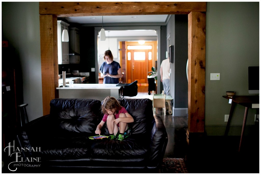 boy plays a game on his ipad while mom cooks