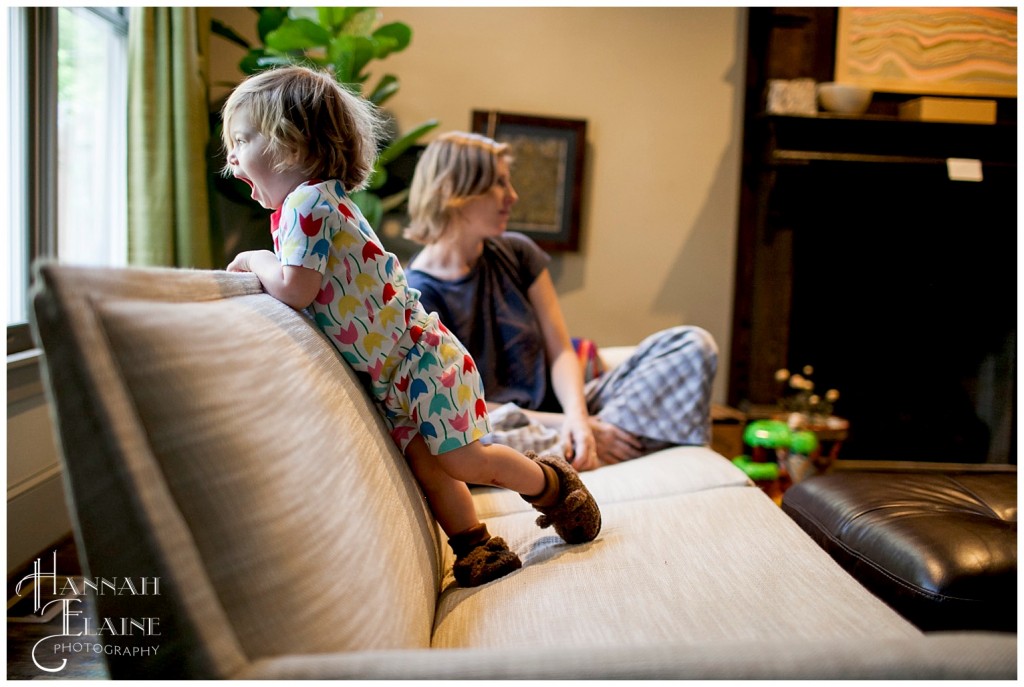 mom and girl sit on the couch together in the morning