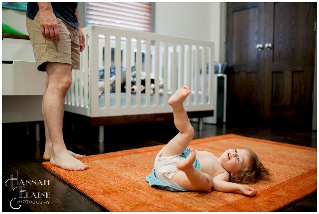 girl rolling around on rug procrastinating getting dressed