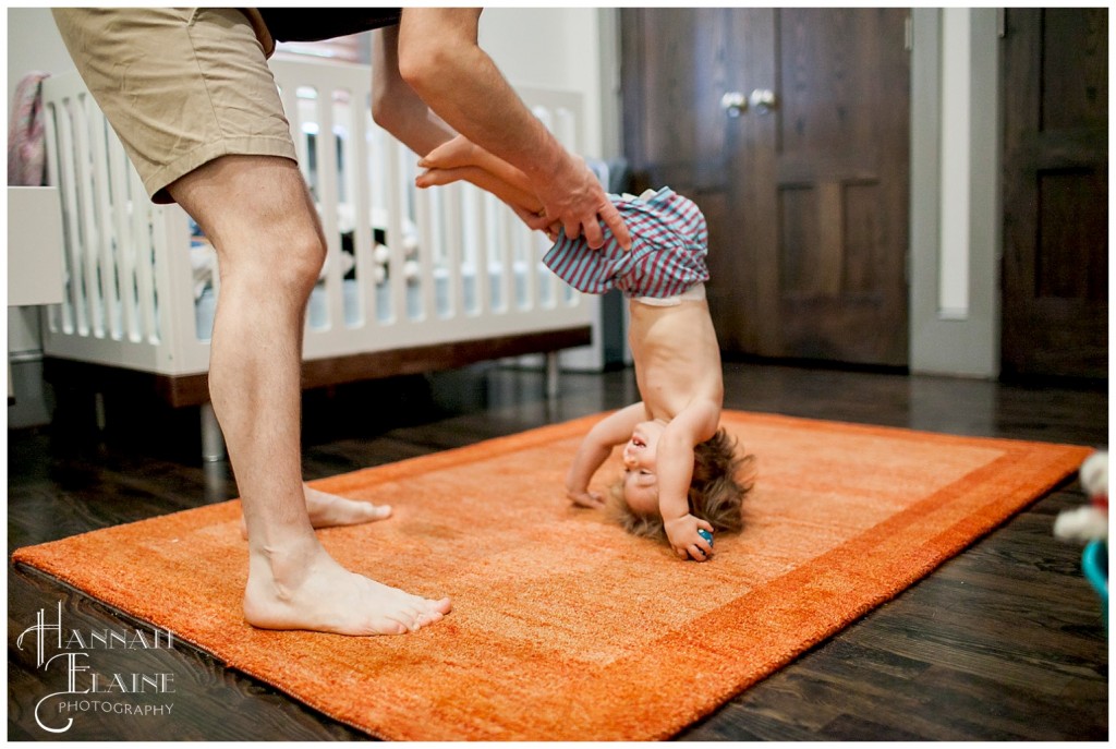 dad helps little girl flip over into a sommersault