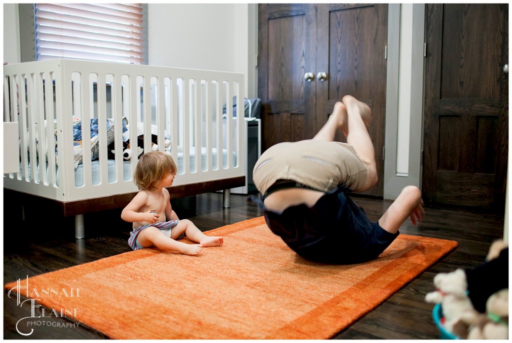 dad demonstrates a sommersault to his daughter