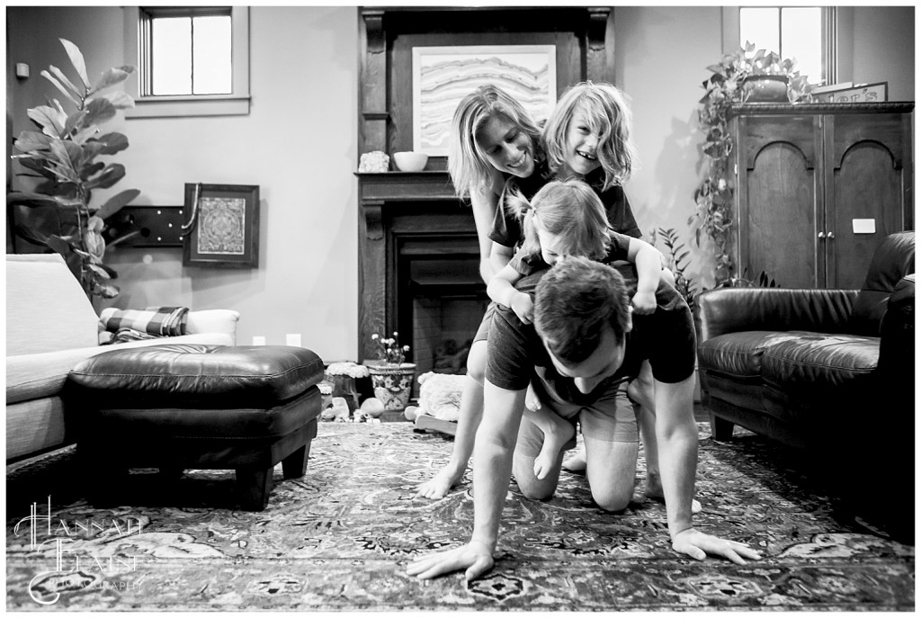 family of four does a dog pile on dad for father's day