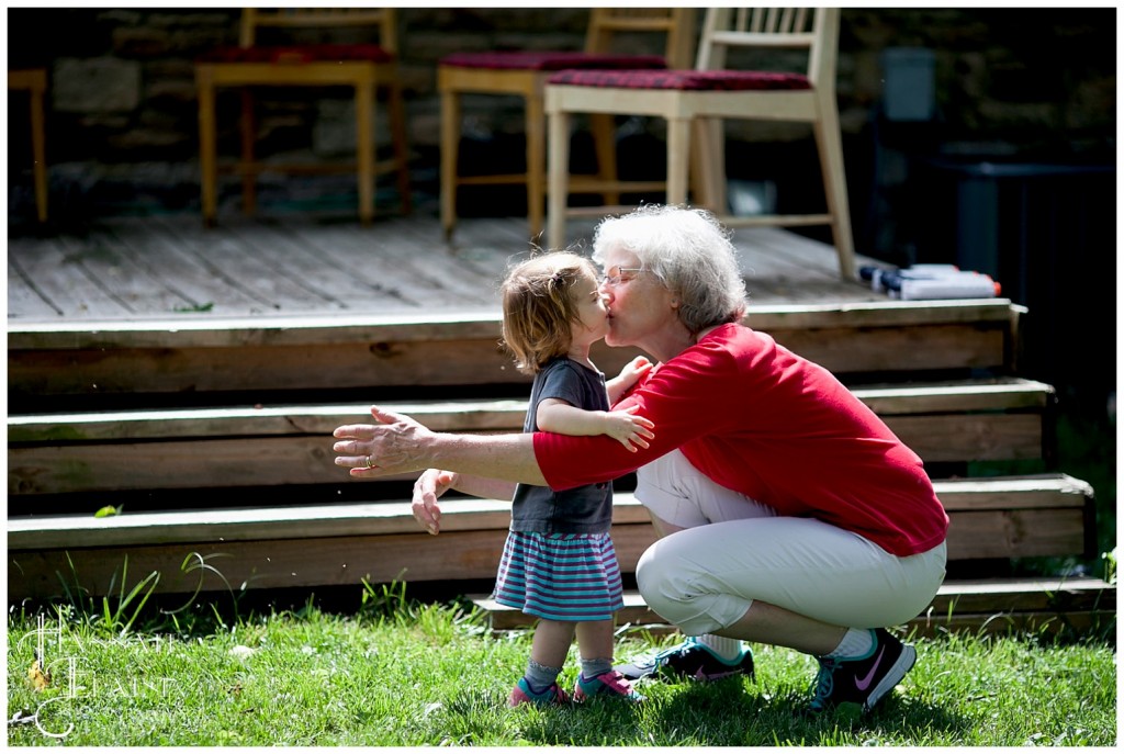 grandma gives her granddaughter a hello kiss