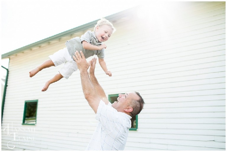 dad throws his smiling youngest son up into the sky