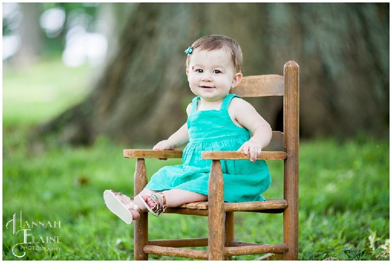 little girl in turquoise sits in vintage rocking chair