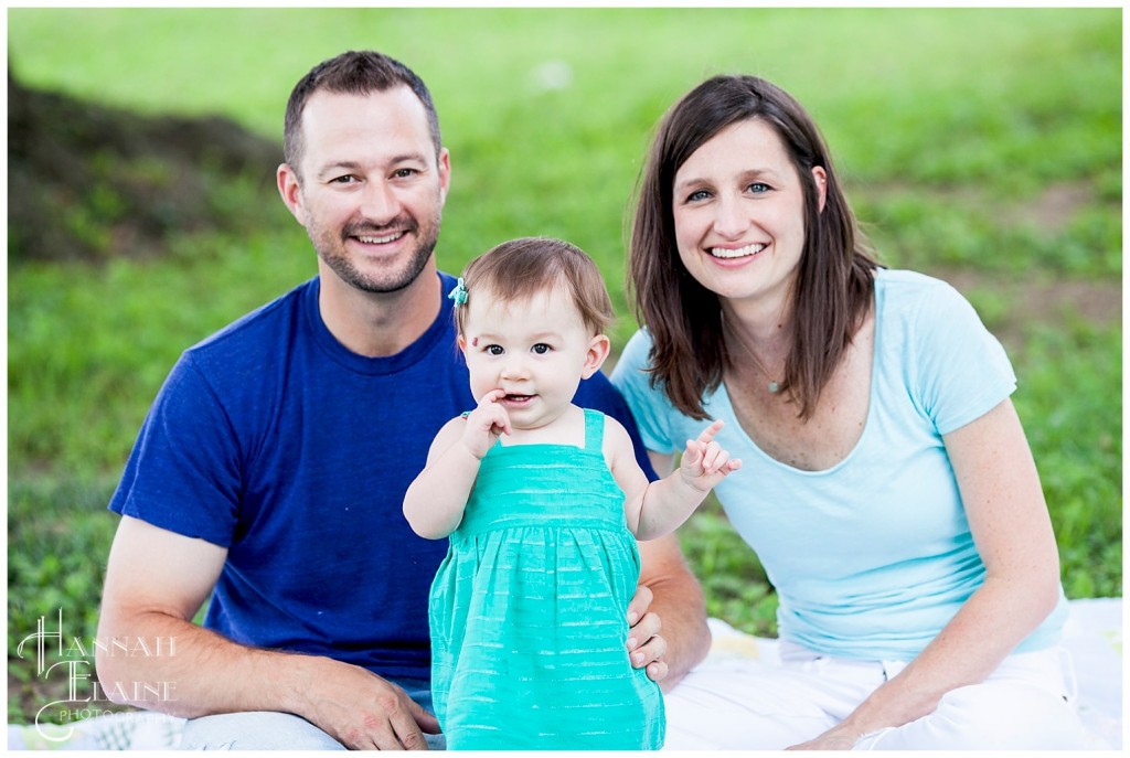 mother and father pose with daughter