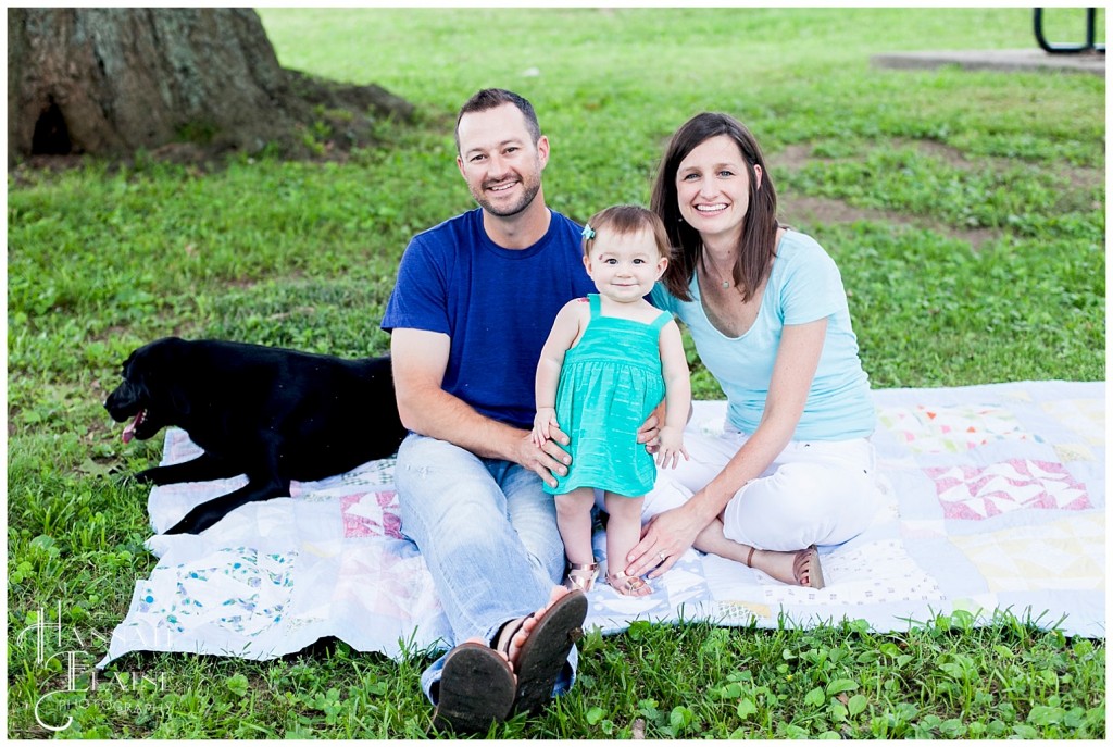 family on blanket in the park with the dog