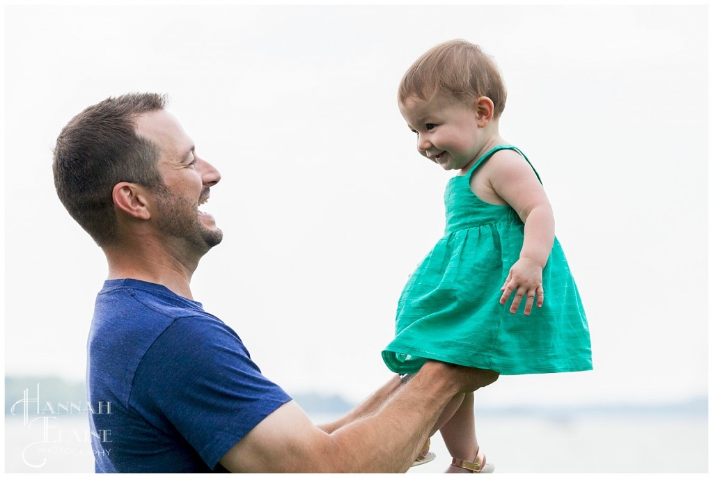 dad hoists his daughter up in the air to get some giggles