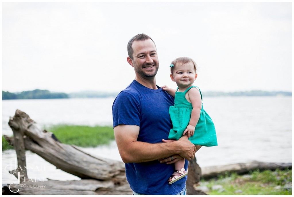 dad and daughter stand by the water's edge at old hickory lake