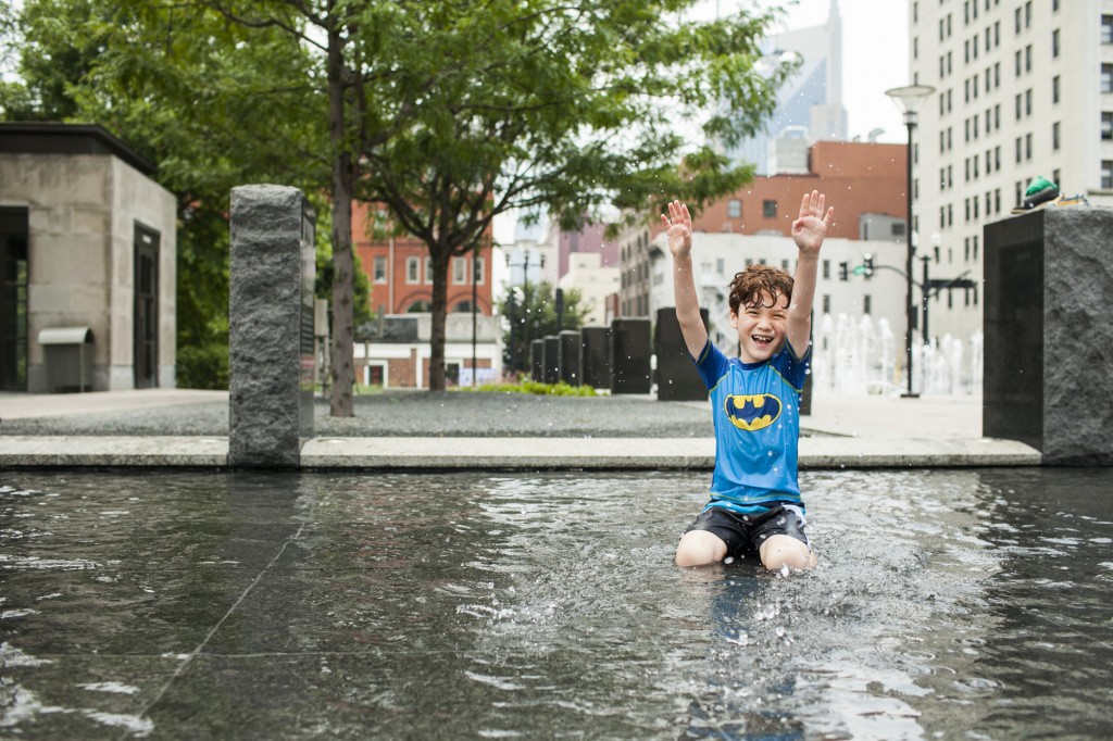 boy in batman shirt splashes the water