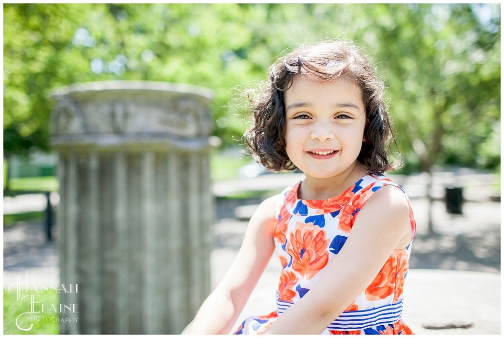 girl with curly brown bob and orange flower dress