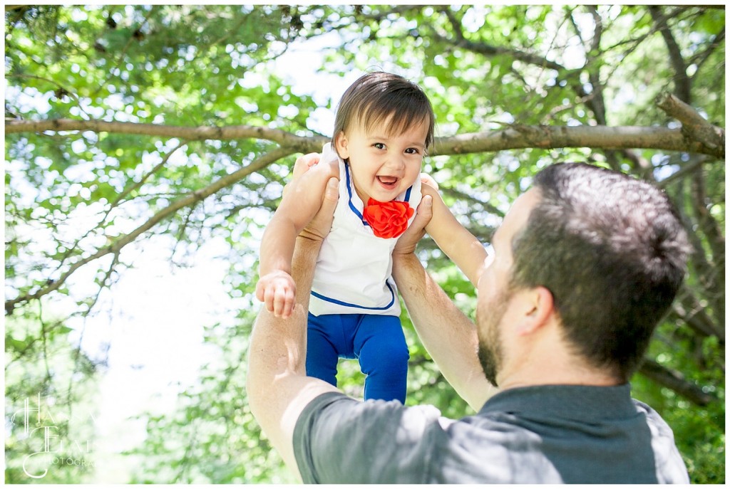 girl smiles as dad hoists her up in the air