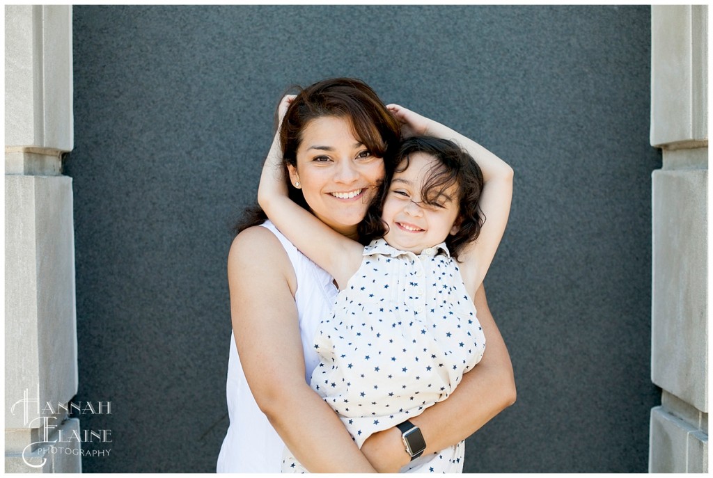 mom with big smile hugs her daughter 