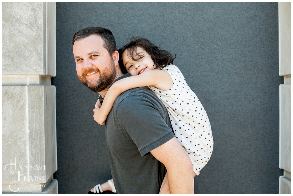 dad carries his daughter on his back for a photo