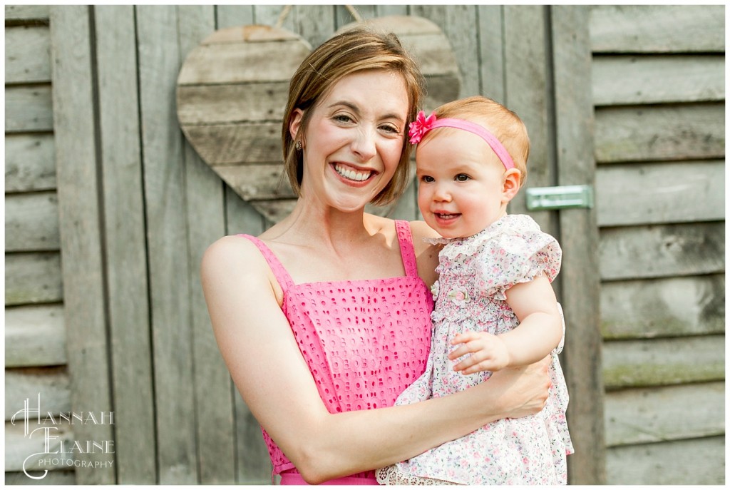 mom and daughter in front of wooden heart