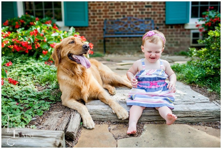 little girl laughs next to her dog who also looks like she's laughing