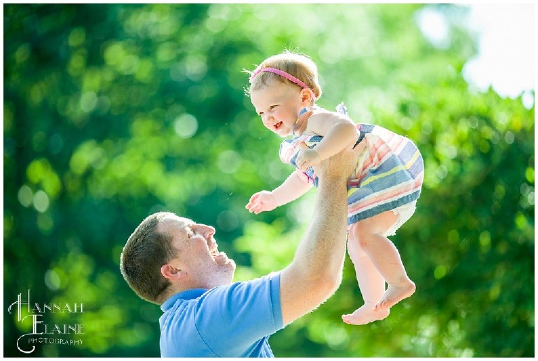 little girl flies up into the air and back into dad's arms